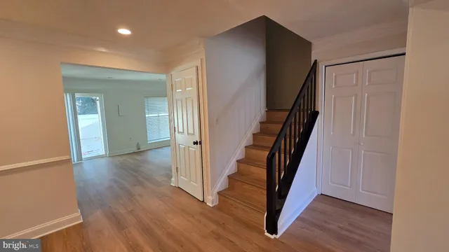 a view of a hallway with wooden floor and stairs