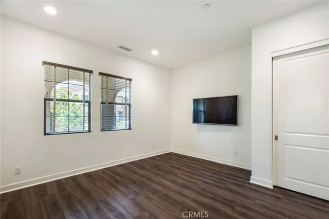 a view of a livingroom with wooden floor and a window
