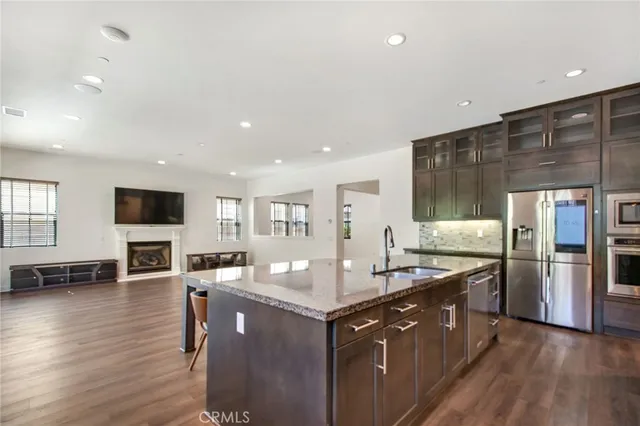 a kitchen with stainless steel appliances granite countertop a sink stove and wooden floor