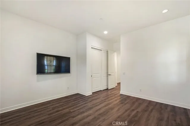 a view of a livingroom with wooden floor and a flat screen tv