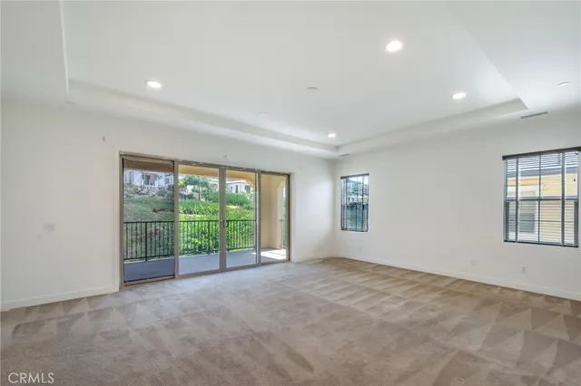 an empty room with windows and view of an empty room