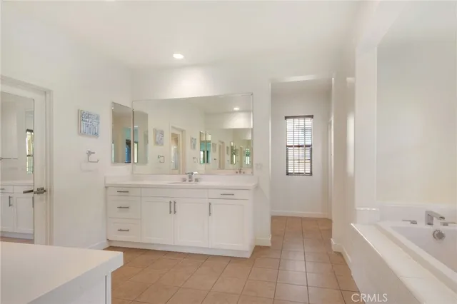 a bathroom with a tub sink and mirror