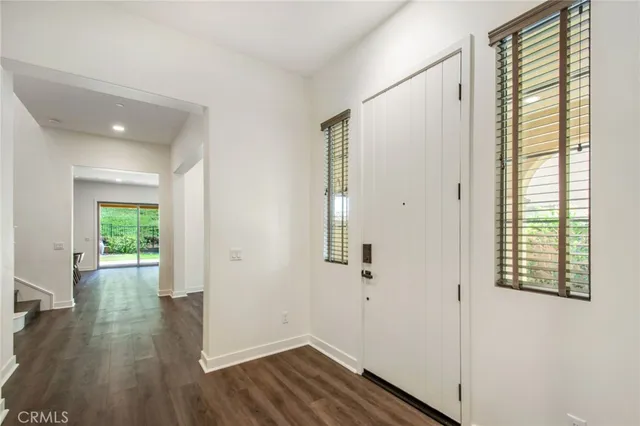 a view of a hallway with wooden floor and closet area