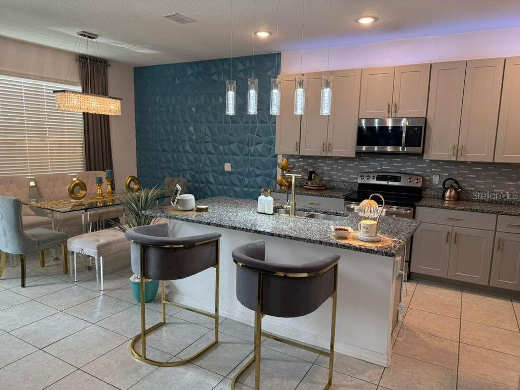 570 Feltrim Manor Road Haines City, FL 33844 - Photo 3 of 18 a kitchen with a sink and chairs