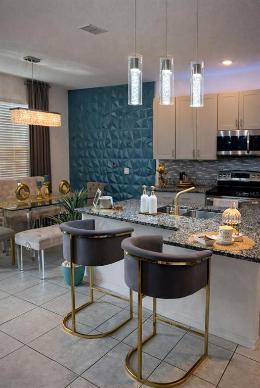 570 Feltrim Manor Road Haines City, FL 33844 - Photo 4 of 18 a kitchen with a sink and chairs