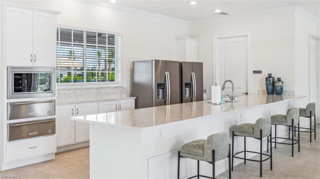 17971 Shade Tree Loop Babcock Ranch, FL 33982 - Photo 17 of 26 The kitchen features white cabinetry, stainless steel appliances, and light-colored countertops