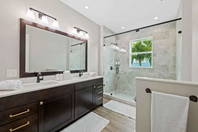 a bathroom with a double vanity sink mirror and shower