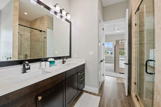 a bathroom with a double vanity sink a mirror and shower