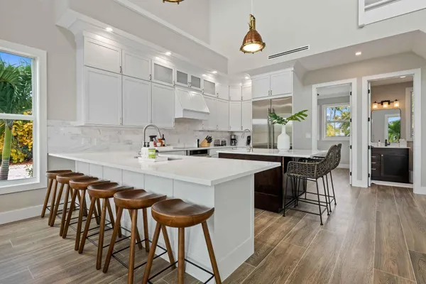 a kitchen with a dining table chairs and white cabinets