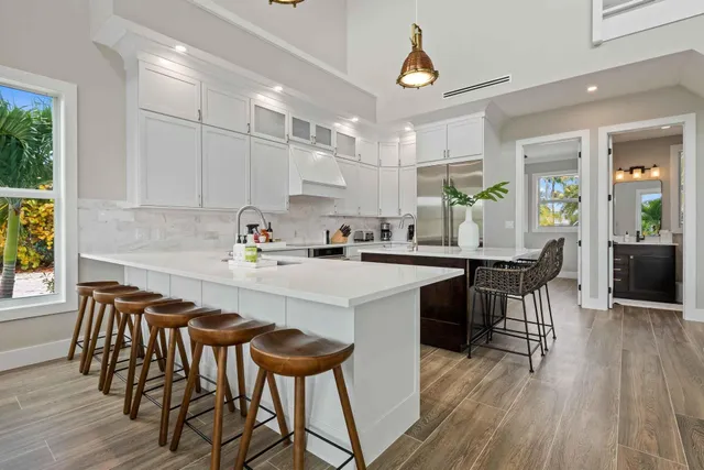 a kitchen with a dining table chairs and white cabinets