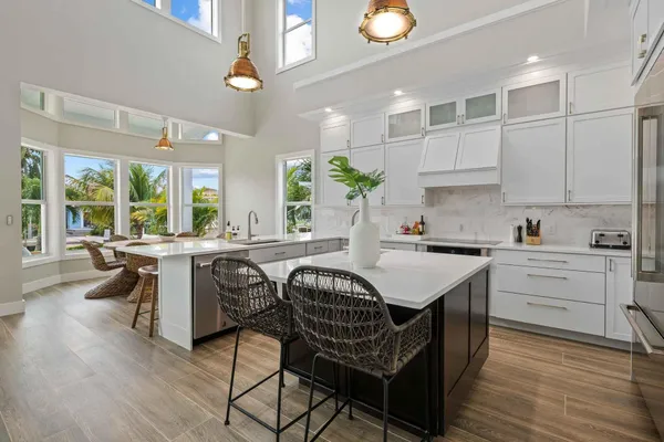 a kitchen with a table chairs stove and white cabinets