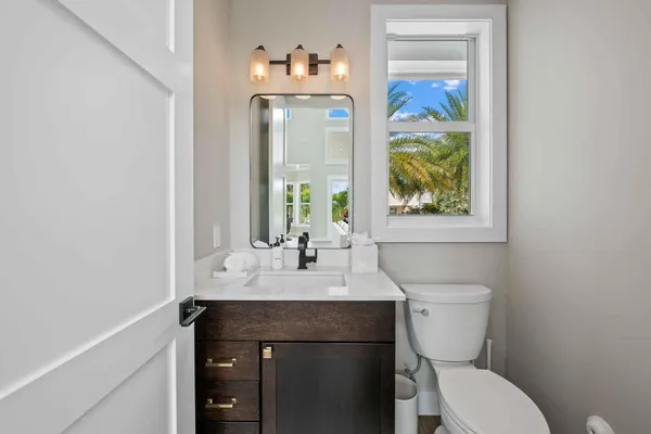 a bathroom with a sink vanity mirror and toilet