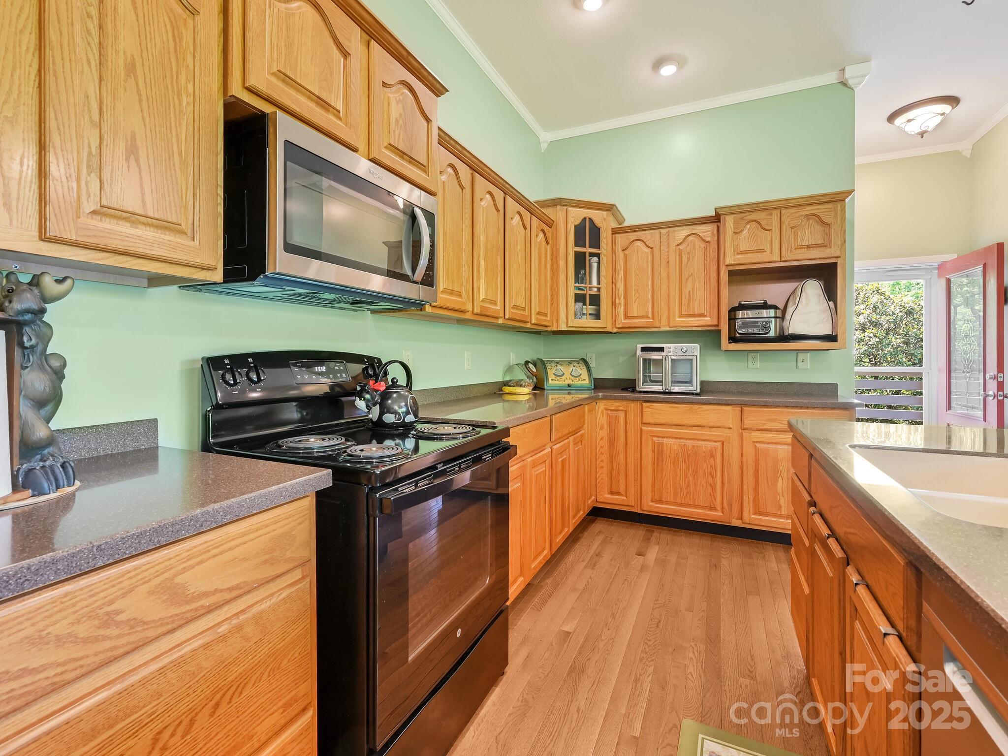 90 Coates Road Marshall, NC 28753 - Photo 23 of 48 a kitchen with stainless steel appliances granite countertop wooden cabinets a stove top oven a sink and dishwasher