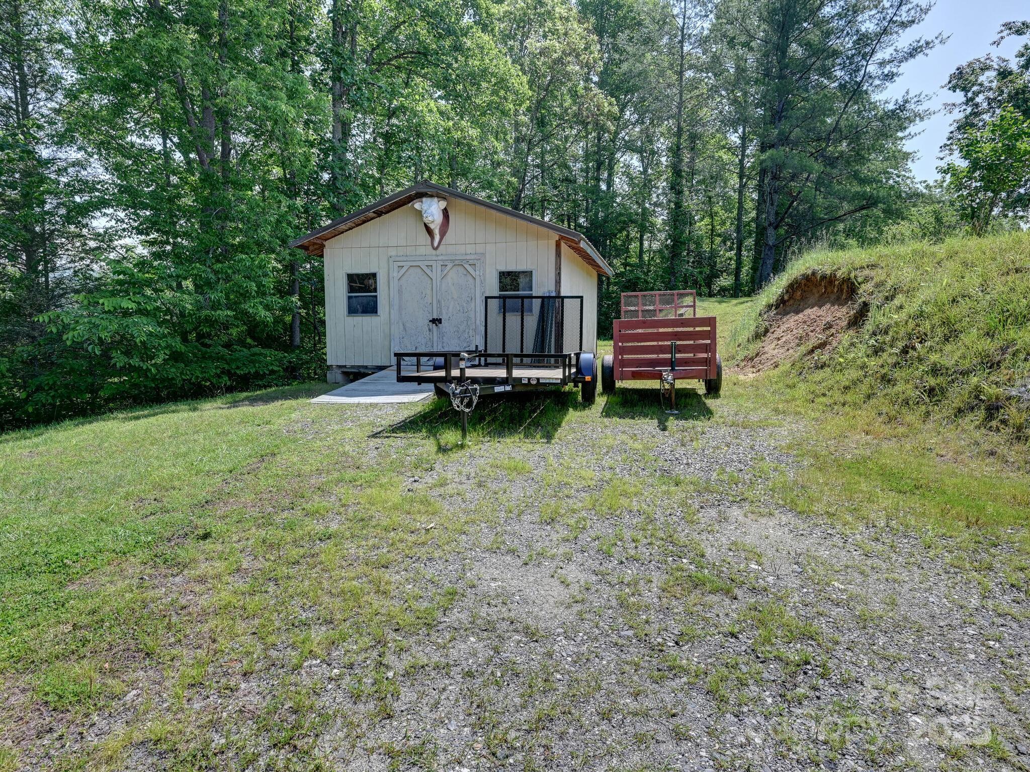 90 Coates Road Marshall, NC 28753 - Photo 39 of 48 a house view with a wooden bench and trees