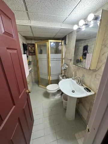 a bathroom with a sink a toilet and shower