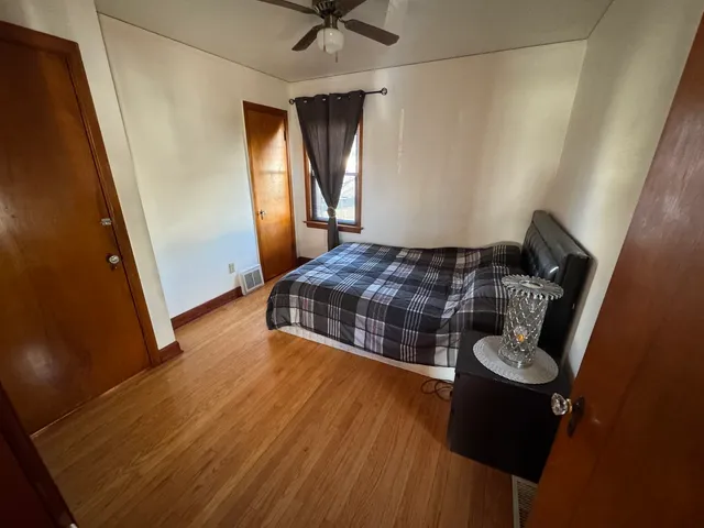 a bedroom with a bed and wooden floor