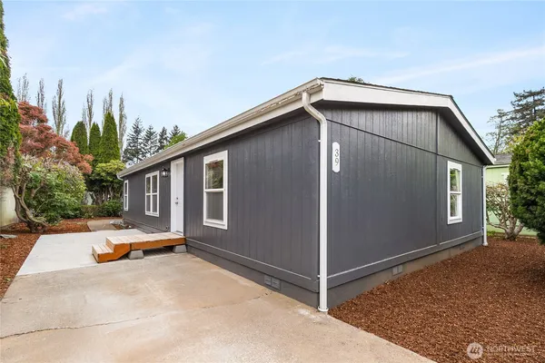 a backyard of a house with tub and trees in the background