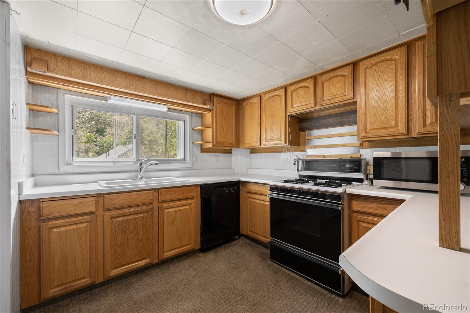 315 Spring Street Morrison, CO 80465 - Photo 13 of 40 a kitchen with stainless steel appliances granite countertop a stove a sink dishwasher and a microwave oven with cabinets