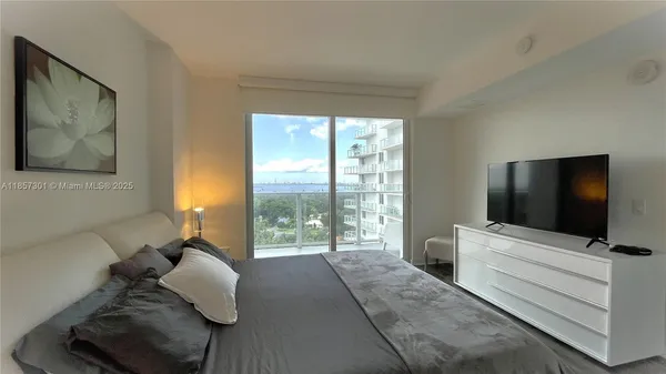 a bedroom with a bed and a large window