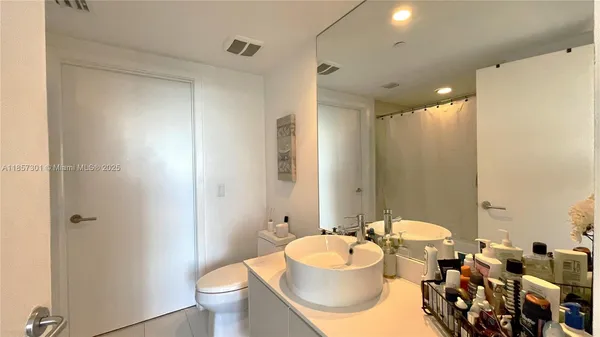 a bathroom with a sink toilet mirror and vanity