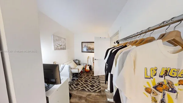 a view of walk in closet with clothes and shoes