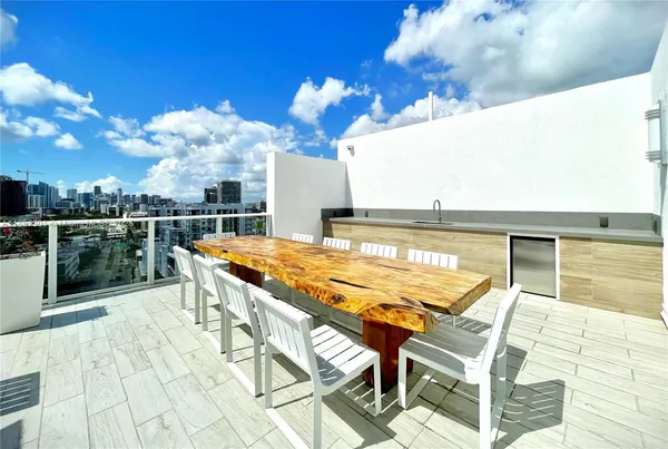 a roof deck with a table and chairs under an umbrella