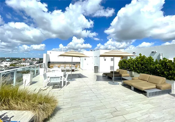 a roof deck with couches and potted plants