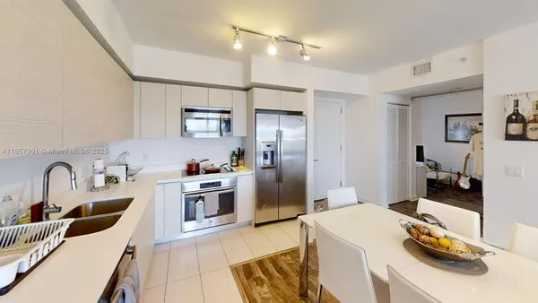 a kitchen with stainless steel appliances kitchen island granite countertop a sink and refrigerator