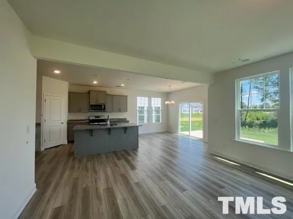 a kitchen with stainless steel appliances kitchen island granite countertop a stove a sink and a refrigerator