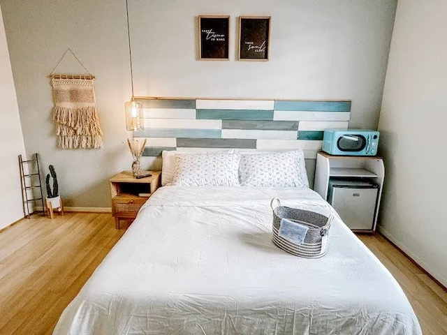 a bedroom with a bed and a flat tv screen on a dresser