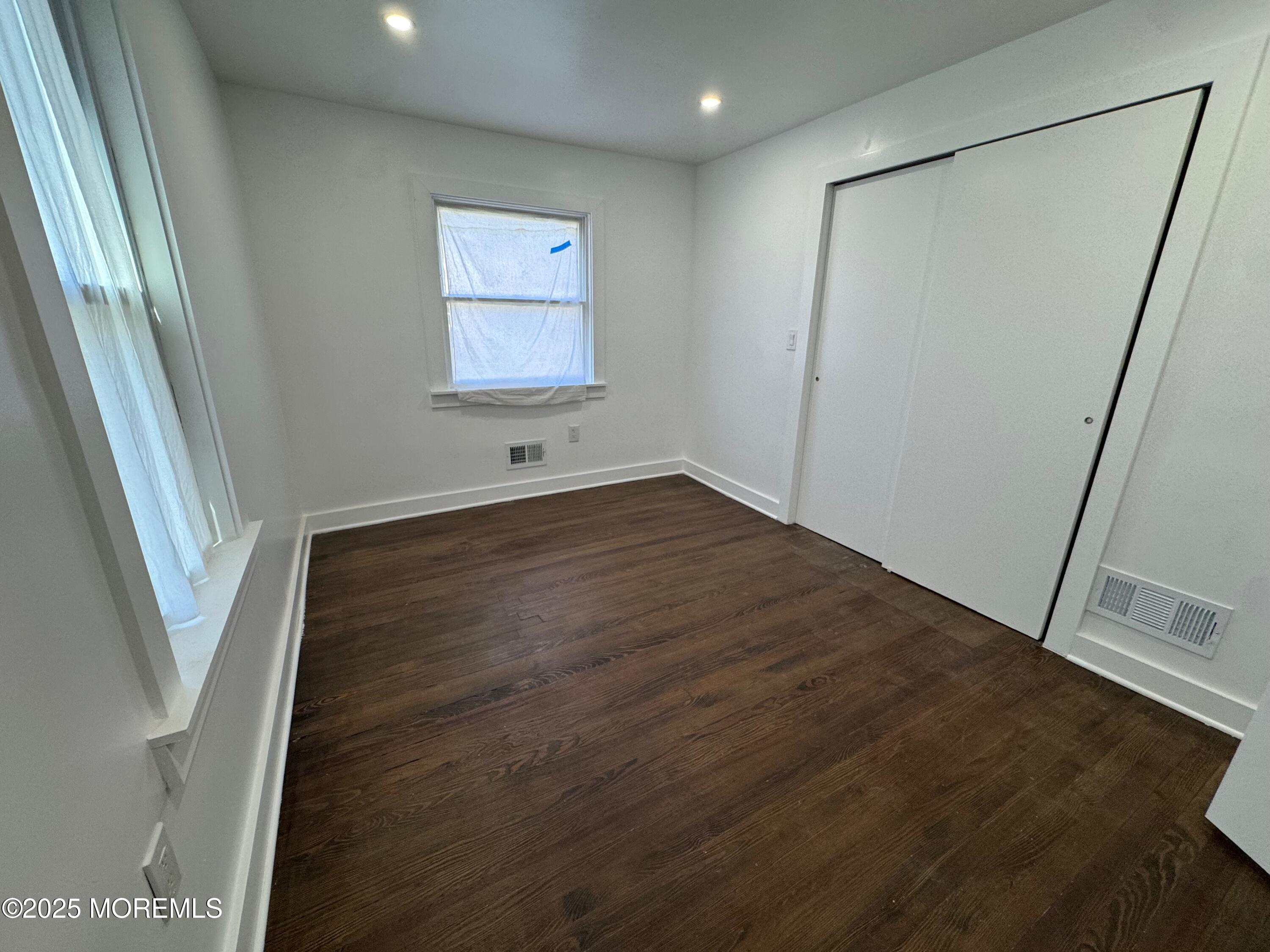 Undisclosed Address Tinton Falls, NJ 07724 - Photo 3 of 8 a view of an empty room with wooden floor and a window