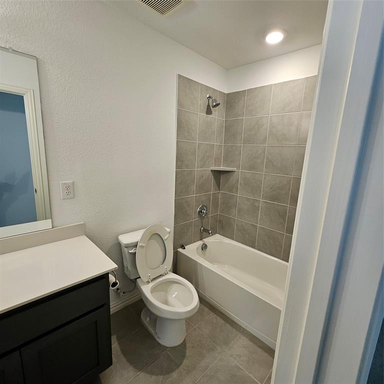 2309 Jack Rabbit Way Northlake, TX 76247 - Photo 16 of 28 Full bathroom featuring a white tub and shower with gray tile surround, a built-in corner shelf, and chrome fixtures