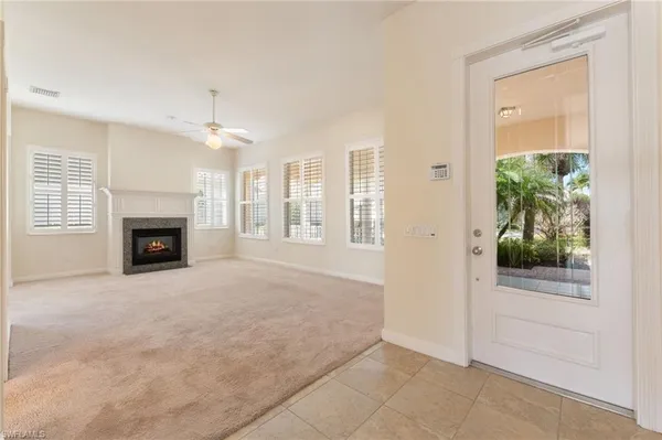 an empty room with windows and fireplace