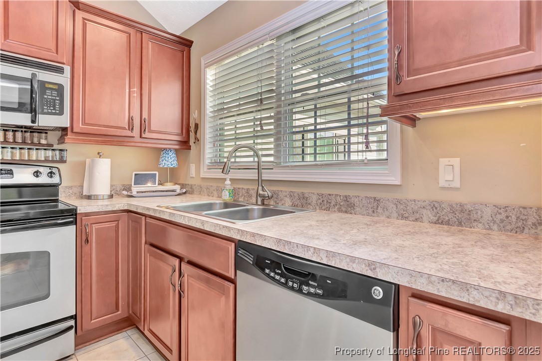 7453 7th Street Road Lumberton, NC 28358 - Photo 13 of 37 a kitchen with granite countertop stainless steel appliances a sink window and cabinets