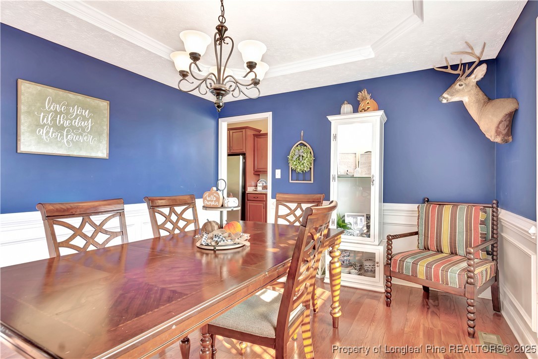 7453 7th Street Road Lumberton, NC 28358 - Photo 17 of 37 a view of a dining room with furniture a chandelier and wooden floor