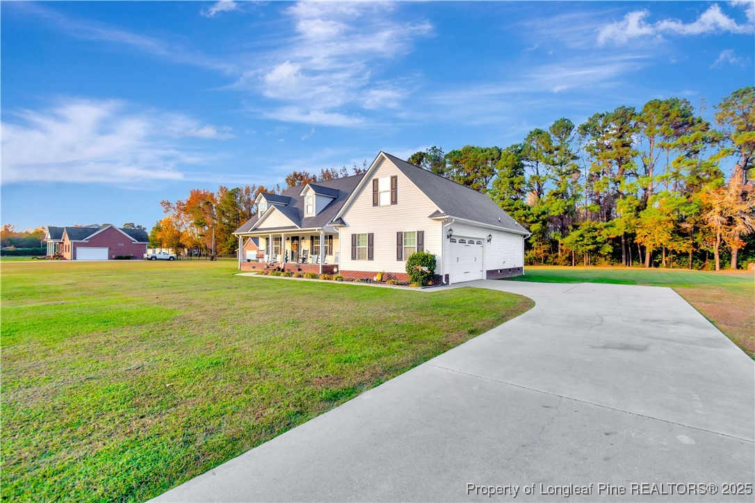 7453 7th Street Road Lumberton, NC 28358 - Photo 2 of 37 a view of house with garden and tall trees