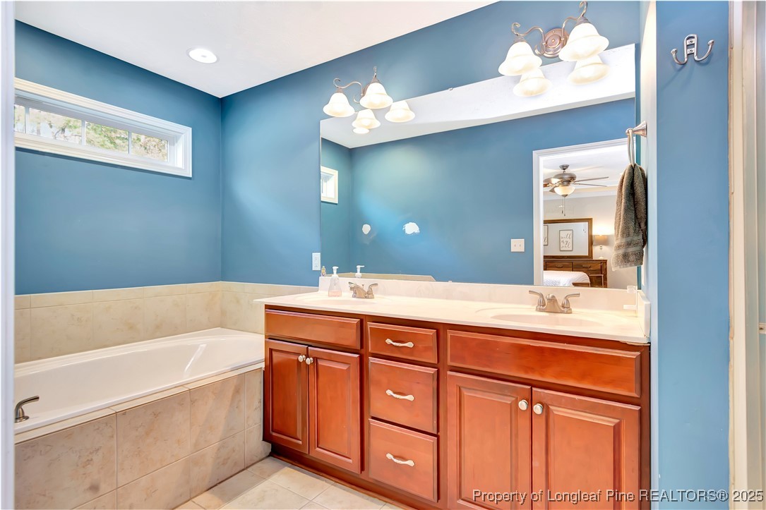 7453 7th Street Road Lumberton, NC 28358 - Photo 23 of 37 a bathroom with a tub a double vanity sink and a mirror