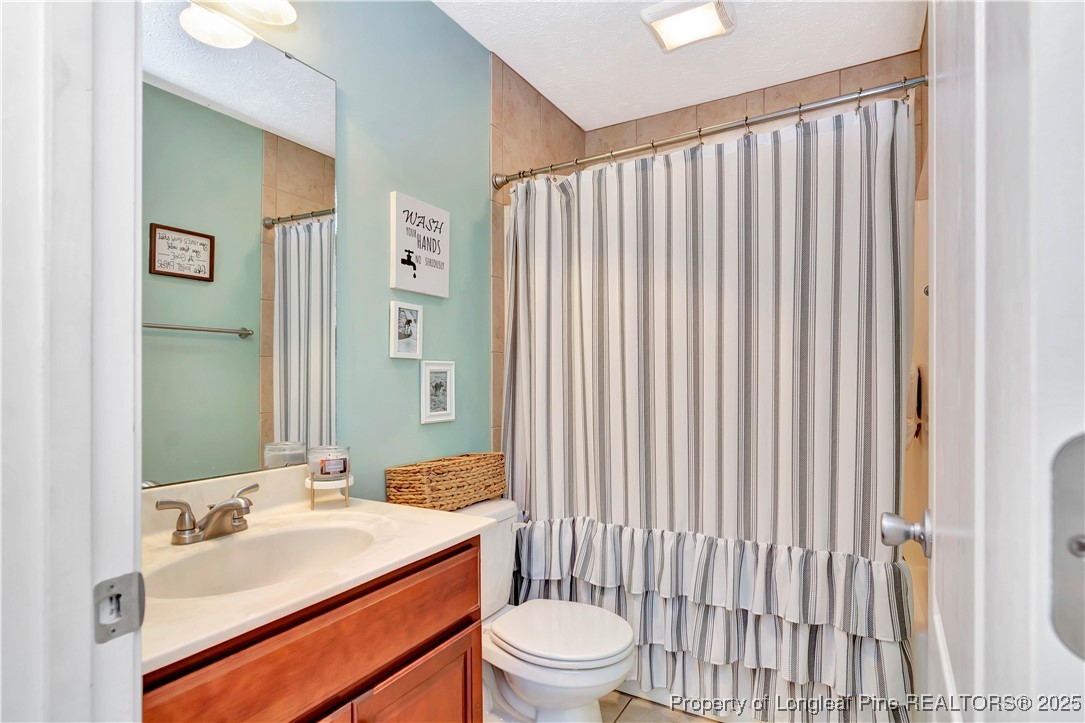 7453 7th Street Road Lumberton, NC 28358 - Photo 28 of 37 a bathroom with a sink a toilet and shower curtain