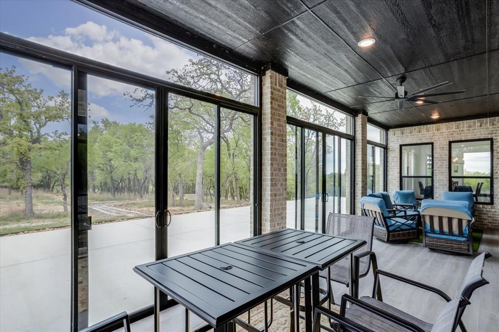 124 Cote D Azur Chico, TX 76431 - Photo 33 of 40 a view of a dining room with furniture large windows and wooden floor