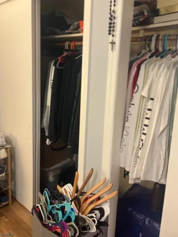 a view of walk in closet with clothes and shoes