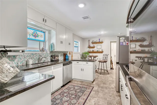 a kitchen with granite countertop lots of counter top space and stainless steel appliances