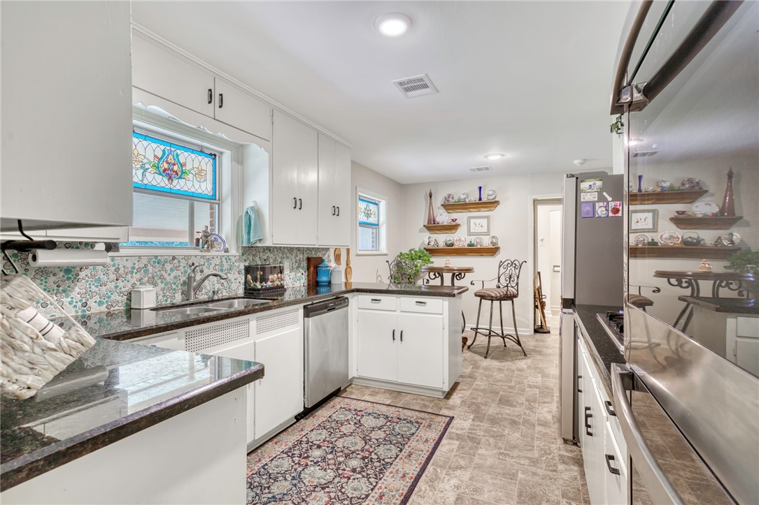 801 North Center Street Franklin, TX 77856 - Photo 12 of 32 Kitchen with dishwasher, a peninsula, white cabinets, a sink, and backsplash