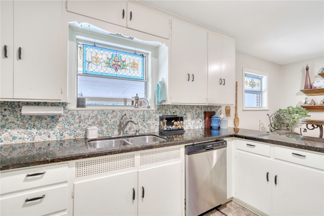 801 North Center Street Franklin, TX 77856 - Photo 14 of 32 Kitchen featuring stainless steel dishwasher, a sink, decorative backsplash, and dark stone countertops