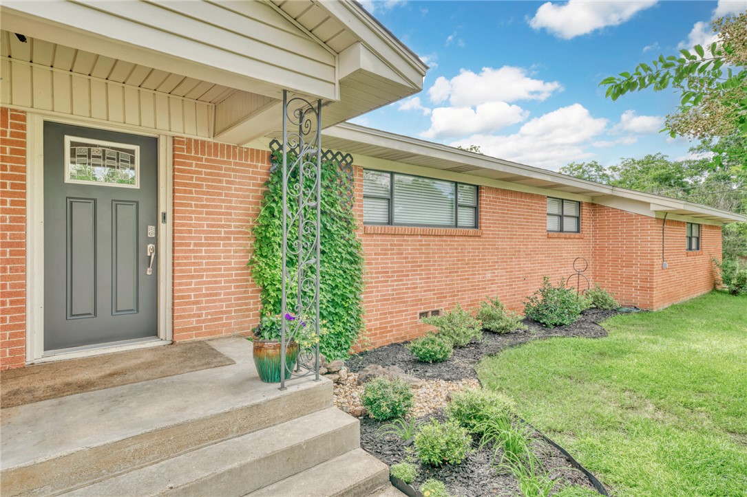 801 North Center Street Franklin, TX 77856 - Photo 2 of 32 View of exterior entry featuring brick siding, a lawn, and crawl space