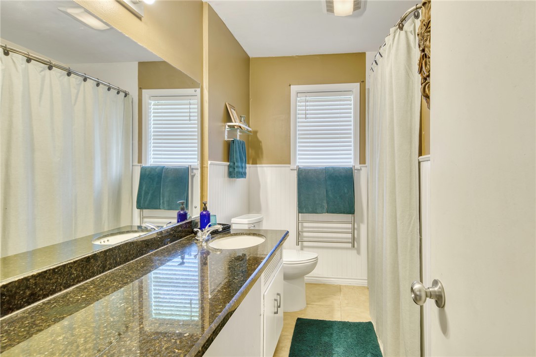 801 North Center Street Franklin, TX 77856 - Photo 22 of 32 Full bath with toilet, tile patterned floors, vanity, and wainscoting