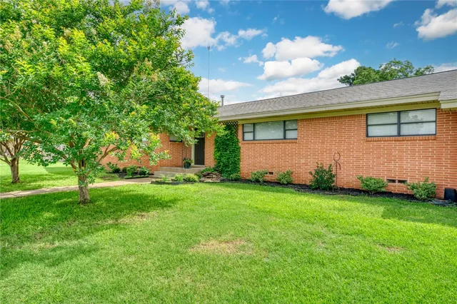 a view of backyard of house with green space