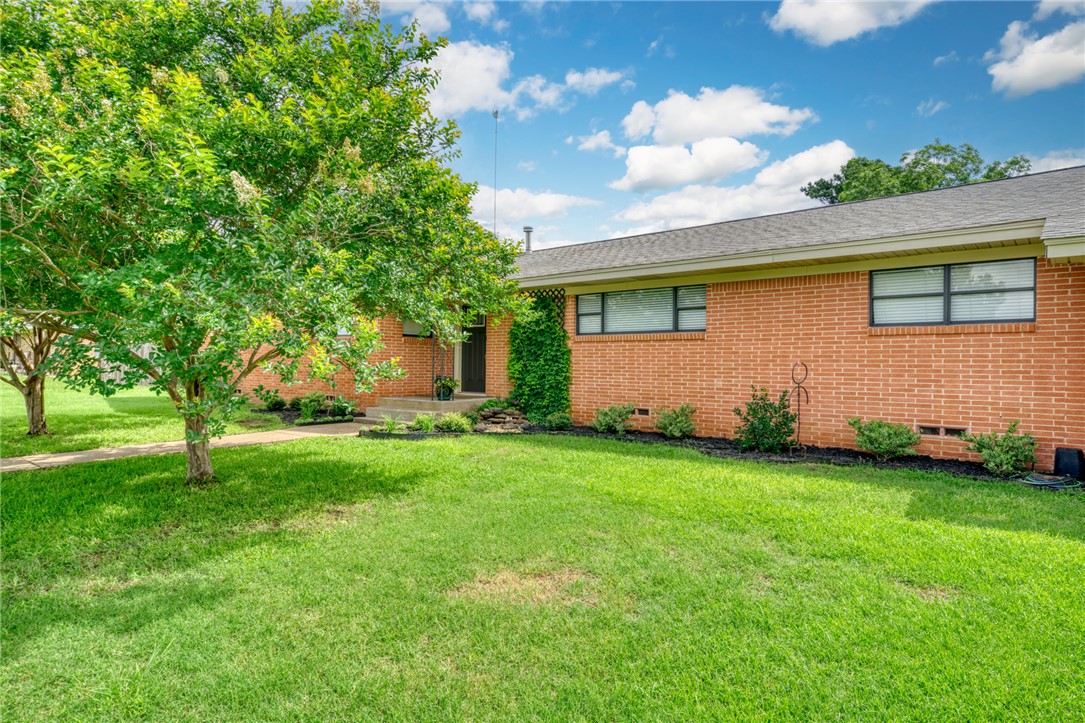 801 North Center Street Franklin, TX 77856 - Photo 3 of 32 Ranch-style house with brick siding, a front lawn, and crawl space