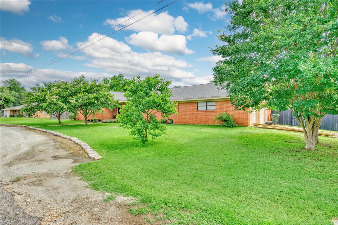 801 North Center Street Franklin, TX 77856 - Photo 4 of 32 View of front of house with brick siding, driveway, and a shingled roof