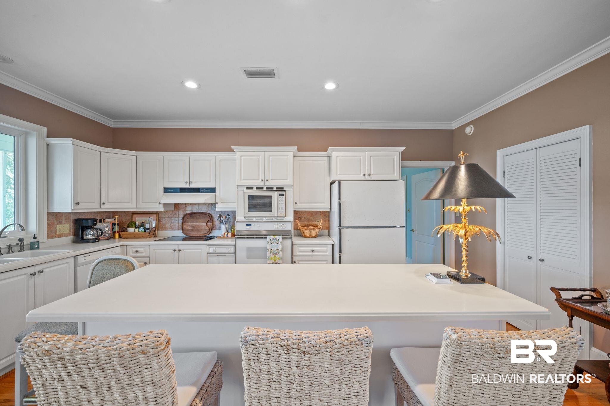 31800 River Road Orange Beach, AL 36561 - Photo 10 of 69 Kitchen featuring sink, white appliances, a kitchen bar, and tasteful backsplash