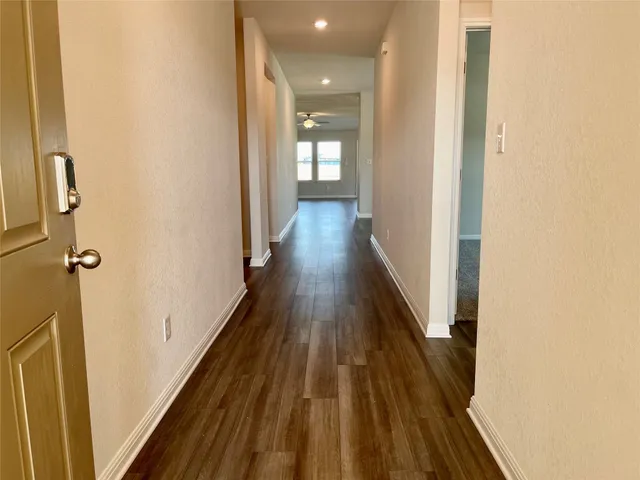 a view of a hallway with wooden floor
